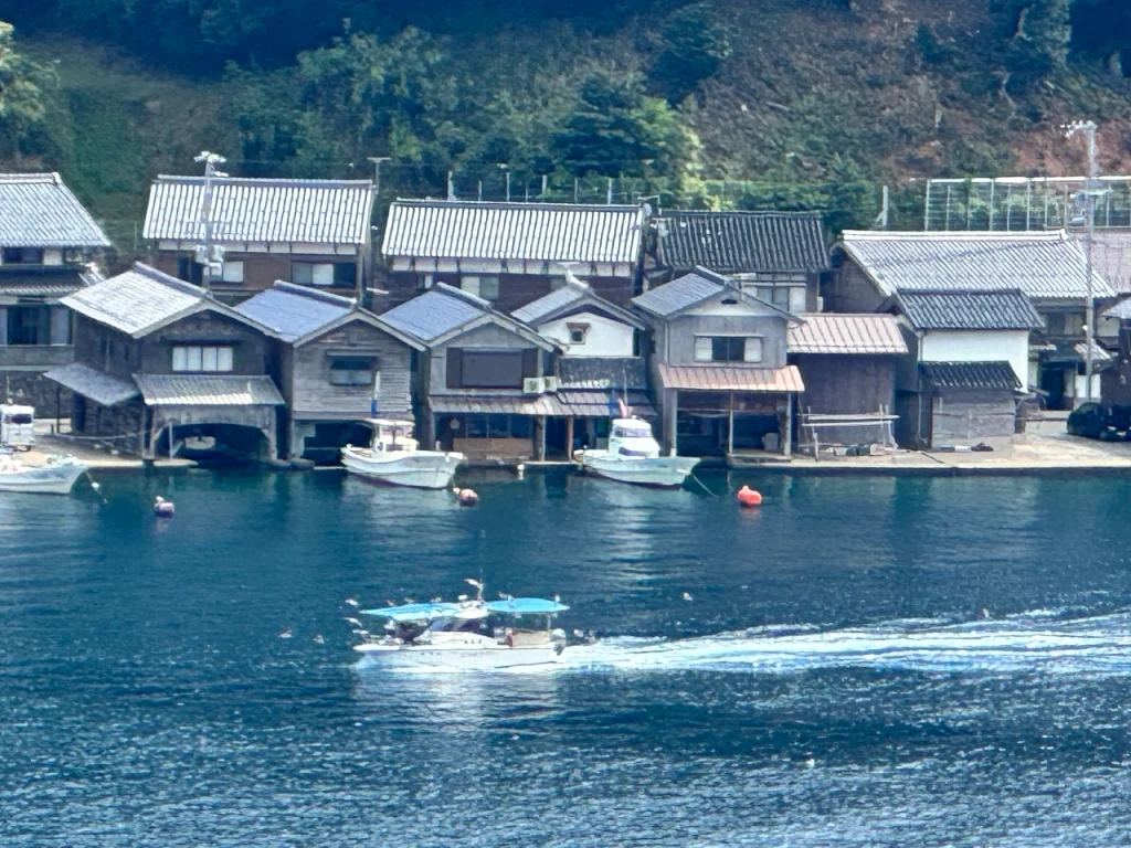 平田埋立地駐車場の小突堤から撮った伊根の舟屋です。舟屋の入口に船が繋がれています。