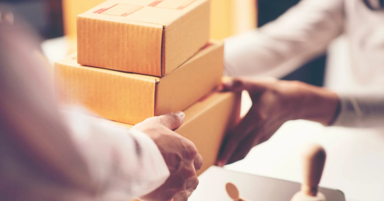 宅配の段ボールを玄関先で受け渡ししている写真