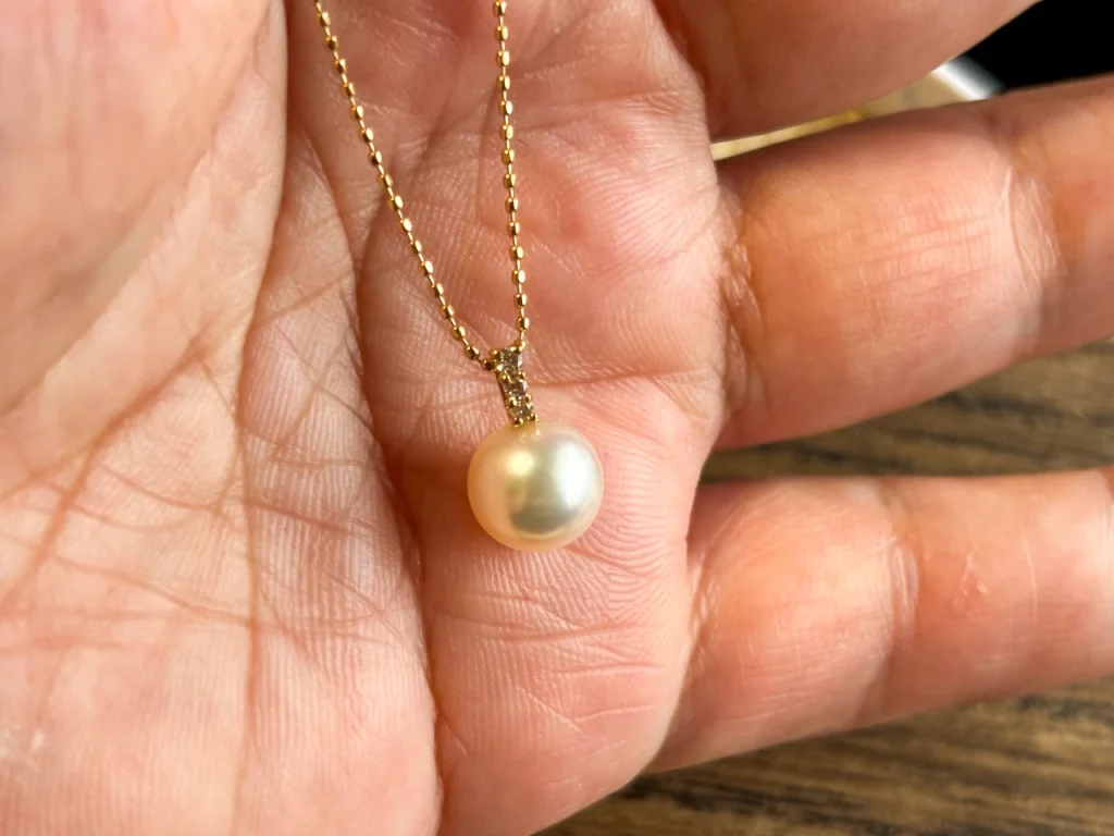 アコヤ真珠のネックレスを手のひらに乗せてみました。うっすらクリーム色を帯びた輝きが美しいです。