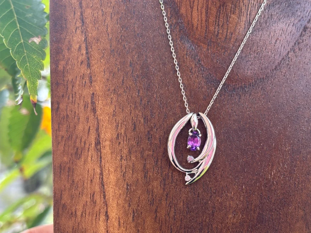 ロズウェイさんのアメシストのネックレスをミニトルソーに掛けて日差しの下で撮りました。 アメシストの色が赤を帯びた紅藤色に変化しています。